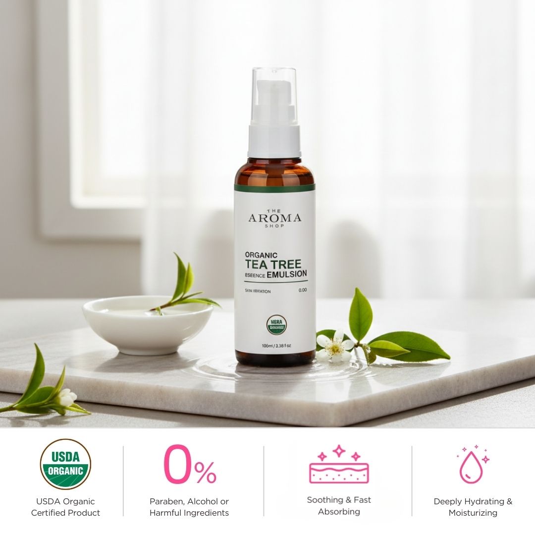 Bottle of Aroma Shop Organic Tea Tree Emulsion on a marble surface with tea leaves.