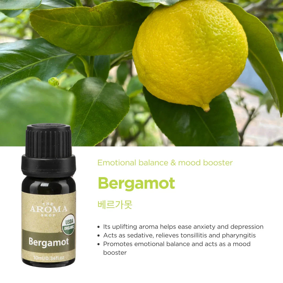 Bergamot oil bottle with lemon and tree leaves in the background