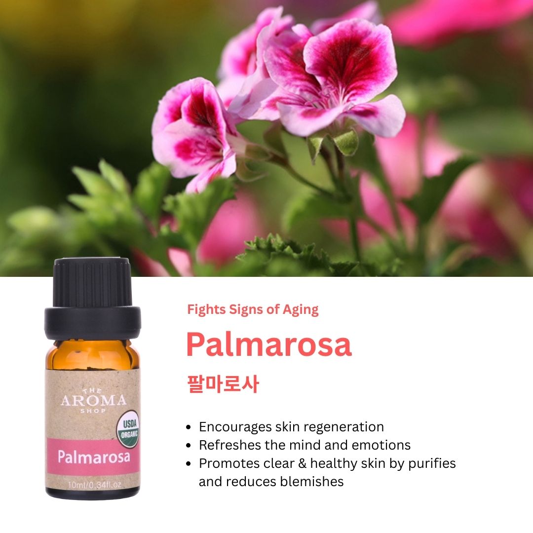 Palmarosa essential oil bottle with pink flowers in the background